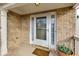 Inviting front entrance with brick surround, decorative columns, and a charming welcome mat and potted plant at 6690 Cold Stream Dr, Cumming, GA 30040