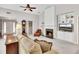 Bright living room featuring a fireplace, a cozy armchair, and an open view of the foyer at 6690 Cold Stream Dr, Cumming, GA 30040