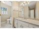 Bathroom with white vanity, granite countertop, mirror, toilet, and window at 7690 Classic Way, Atlanta, GA 30350