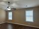 A bedroom featuring a ceiling fan, two windows, dark wood flooring and neutral-colored walls at 875 Under Ct, Sugar Hill, GA 30518