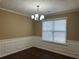 Cozy dining room with wainscoting, chandelier lighting, and a large window for natural light at 875 Under Ct, Sugar Hill, GA 30518