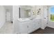 Bright bathroom with double vanity, framed mirror and wood look floor at 708 Ocmulgee Xing, Locust Grove, GA 30248