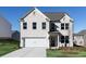 Charming two-story home with a white brick facade, a two-car garage, and a well-maintained lawn at 708 Ocmulgee Xing, Locust Grove, GA 30248