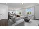 Open concept living room leading to kitchen with neutral furniture, bright windows, and modern decor at 708 Ocmulgee Xing, Locust Grove, GA 30248