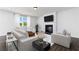 Cozy living room with fireplace, large screen tv, neutral colored furniture, and bright windows with curtains at 708 Ocmulgee Xing, Locust Grove, GA 30248