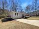 Charming home exterior with a large yard, concrete driveway, and wooden stairs and deck at 8072 Crystal Ln, Douglasville, GA 30134