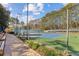 Community tennis court with green and blue surface, surrounded by trees and fence at 1334 Wyntercreek Ln, Dunwoody, GA 30338