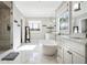 Bright bathroom boasts a soaking tub, marble floors, glass shower, and dual sink vanity at 14 Long Island Pl., Atlanta, GA 30328