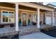 Inviting front porch with brick flooring, classic columns, and stylish seating, perfect for relaxing outdoors at 14 Long Island Pl., Atlanta, GA 30328