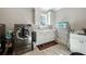 Well-lit laundry room featuring a stainless steel washer and dryer, folding counter, and utility sink at 14 Long Island Pl., Atlanta, GA 30328