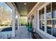 Relaxing side porch with brick flooring, white columns, and views of the surrounding neighborhood at 14 Long Island Pl, Atlanta, GA 30328