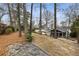 Expansive backyard featuring mature trees, stone accents, and a screened-in porch for outdoor relaxation at 2044 Cottage Nw Ln, Atlanta, GA 30318