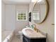 Bathroom featuring black vanity, marble counters, subway tile and brass finishes at 2044 Cottage Nw Ln, Atlanta, GA 30318
