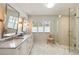 Bright primary bath with double vanity, glass shower, and marble floors at 2044 Cottage Nw Ln, Atlanta, GA 30318