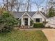 Inviting white-painted home with an ornate porch, manicured hedges, and a walkway leading to the entrance at 2044 Cottage Nw Ln, Atlanta, GA 30318