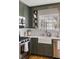 Farmhouse sink and stainless steel appliances pair well with the olive-colored cabinets in this kitchen at 2044 Cottage Nw Ln, Atlanta, GA 30318
