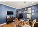 A home office features blue walls and a large glass desk, creating a modern workspace at 2044 Cottage Nw Ln, Atlanta, GA 30318