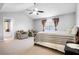 Bright bedroom with vaulted ceiling, ceiling fan, sitting area, and doorway to bathroom at 225 Stonewood Ct, Temple, GA 30179