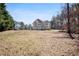 Exterior view of the home features a large yard, mature trees, and a two-car garage at 225 Stonewood Ct, Temple, GA 30179