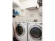 Functional laundry room with a washer, dryer, shelving, and ample space for laundry tasks at 225 Stonewood Ct, Temple, GA 30179