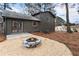 Backyard featuring fire pit, gravel surround, dark green siding, and level landscaping at 4397 Shady Drive Nw, Lilburn, GA 30047