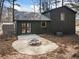 Backyard featuring fire pit, gravel surround, dark green siding, and level landscaping at 4397 Shady Drive Nw, Lilburn, GA 30047