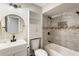 Bathroom with a tub, tiled shower, white vanity, gold mirror, and black fixtures at 4397 Shady Drive Nw, Lilburn, GA 30047
