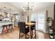 Stylish dining area featuring a modern chandelier, seamless flow to the kitchen, and access to the outdoors at 4397 Shady Drive Nw, Lilburn, GA 30047