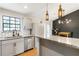 Kitchen featuring granite countertops, stainless steel appliances, a breakfast bar, and designer lighting at 4397 Shady Drive Nw, Lilburn, GA 30047