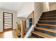 Staircase with natural wood steps and black accents, leading to the upper level of the home at 4397 Shady Drive Nw, Lilburn, GA 30047