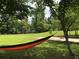 Relaxing backyard featuring mature trees with a comfortable orange and black hammock for lounging at 2948 Legion Lake Rd, Douglasville, GA 30135