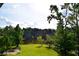 Expansive backyard with lush lawn, stone seawall, and mature trees overlooking a serene lake at 2948 Legion Lake Rd, Douglasville, GA 30135