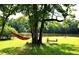 Expansive backyard featuring a hammock and swings overlooking a serene lake view and lush greenery at 2948 Legion Lake Rd, Douglasville, GA 30135