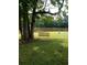 Scenic backyard view showcasing a classic wooden swing hanging from a sturdy tree overlooking the calm lake at 2948 Legion Lake Rd, Douglasville, GA 30135