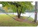 Relaxing backyard scene with a colorful hammock strung between trees near a tranquil lake at 2948 Legion Lake Rd, Douglasville, GA 30135
