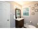 Cozy bathroom featuring a vanity with storage, a decorative mirror, and plenty of natural light at 2948 Legion Lake Rd, Douglasville, GA 30135