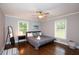 Modern bedroom with wood flooring, ceiling fan, accent mirror, and large windows for ample natural light at 2948 Legion Lake Rd, Douglasville, GA 30135