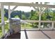 Outdoor grill, propane tank, wooden deck, and railings overlooking greenery at 2948 Legion Lake Rd, Douglasville, GA 30135