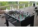 Outdoor deck featuring a foosball table for entertainment, with a scenic lake view and outdoor seating at 2948 Legion Lake Rd, Douglasville, GA 30135
