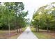Long driveway leading to a charming home surrounded by lush trees at 2948 Legion Lake Rd, Douglasville, GA 30135