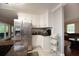 Open kitchen with stainless steel refrigerator, white cabinets and granite counters at 2948 Legion Lake Rd, Douglasville, GA 30135