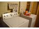 Well-equipped laundry area with modern washing machine and dryer, featuring a vintage-inspired sign at 2948 Legion Lake Rd, Douglasville, GA 30135
