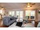 Well-lit living room with hardwood floors, ceiling fans, gray furniture, and access to the outdoor space at 2948 Legion Lake Rd, Douglasville, GA 30135