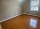 Bedroom showcasing hardwood floors and a window with blinds for natural light control at 5790 Northspring Dr, Ellenwood, GA 30294