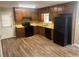 Cozy kitchen with wood cabinets, black appliances, and vinyl flooring at 5790 Northspring Dr, Ellenwood, GA 30294