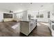 Bright kitchen with an island and a view of the living room with large windows and modern decor at 1183 Lanier Springs Dr, Buford, GA 30518