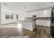 Modern kitchen featuring white cabinetry, an island with a granite countertop, and stainless-steel appliances at 1183 Lanier Springs Dr, Buford, GA 30518