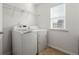 Bright laundry room featuring a washer, dryer, tile flooring, and a wire rack shelf for organized storage solutions at 1183 Lanier Springs Dr, Buford, GA 30518