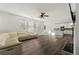 Open-concept living room featuring hardwood floors, a white leather sofa, and a view into the kitchen at 1183 Lanier Springs Dr, Buford, GA 30518