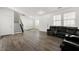 Cozy living room with hardwood floors, a staircase, and a comfortable black leather sofa at 1183 Lanier Springs Dr, Buford, GA 30518